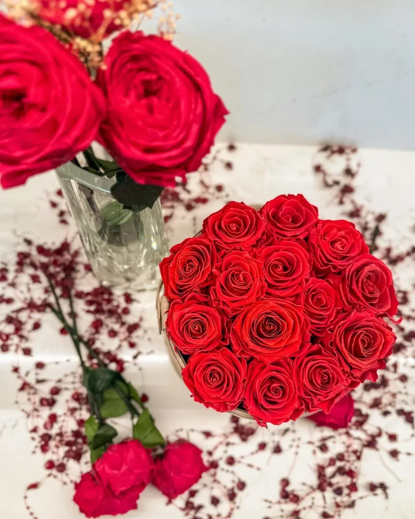 Vibrant red roses in a glass vase and bouquet, biophilic floral decor by Trendy Gardener
