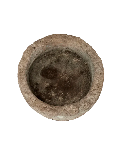 Top view of a round limestone trough planter with rustic stone texture