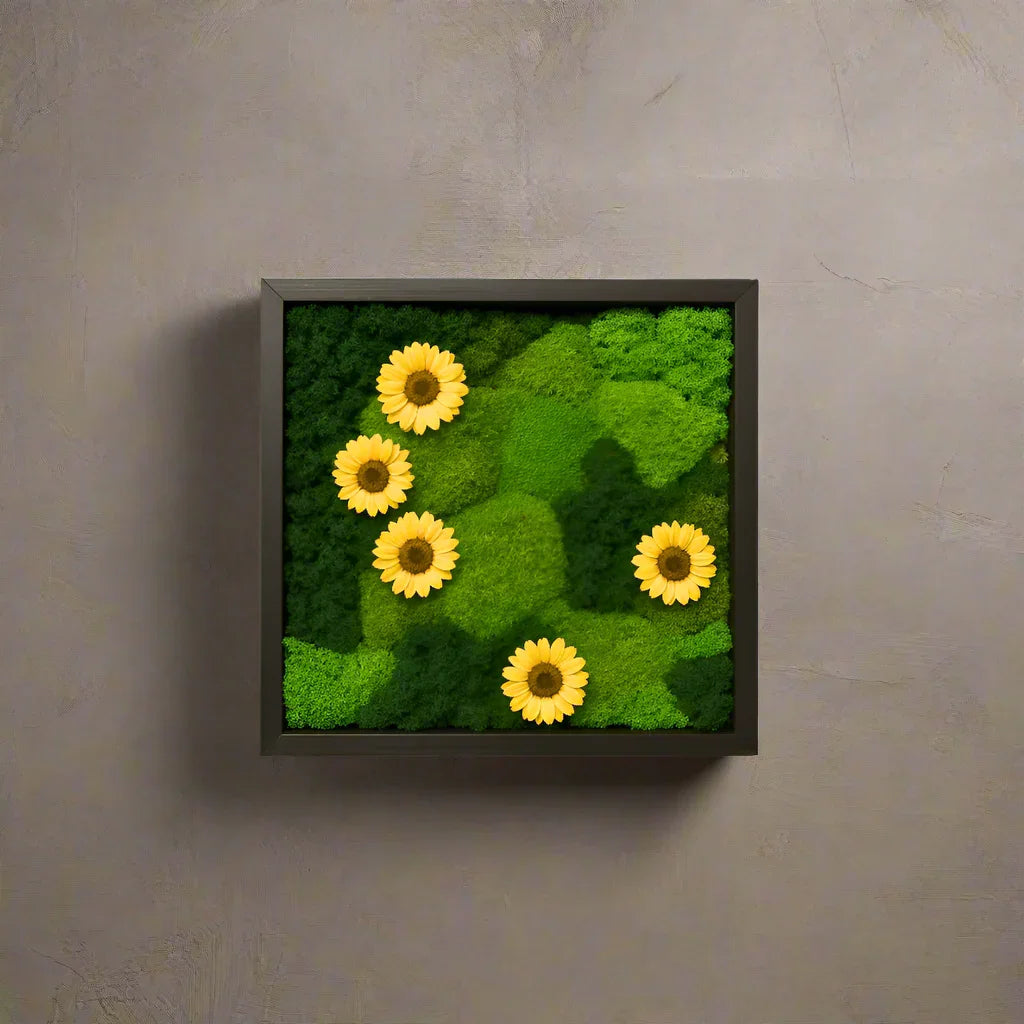 Sunrise Meadow moss frame featuring preserved golden yellow sunflower blooms, reindeer moss, and mood moss arranged in a 12x12in hardwood frame.