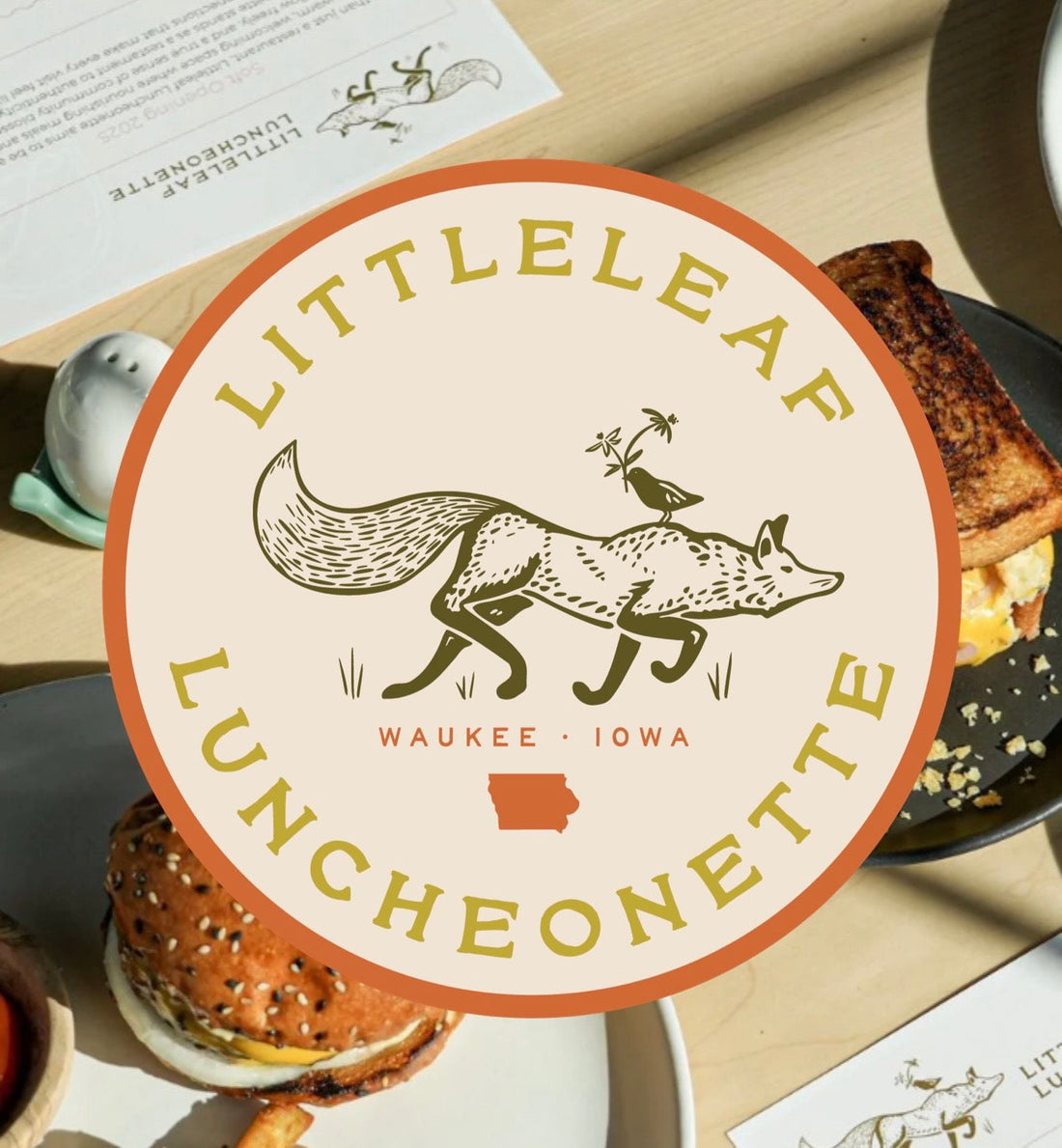 Littleleaf Luncheonette logo featuring a fox illustration with a small bird holding flowers, with “Waukee, Iowa” and an Iowa icon inside a circular badge.