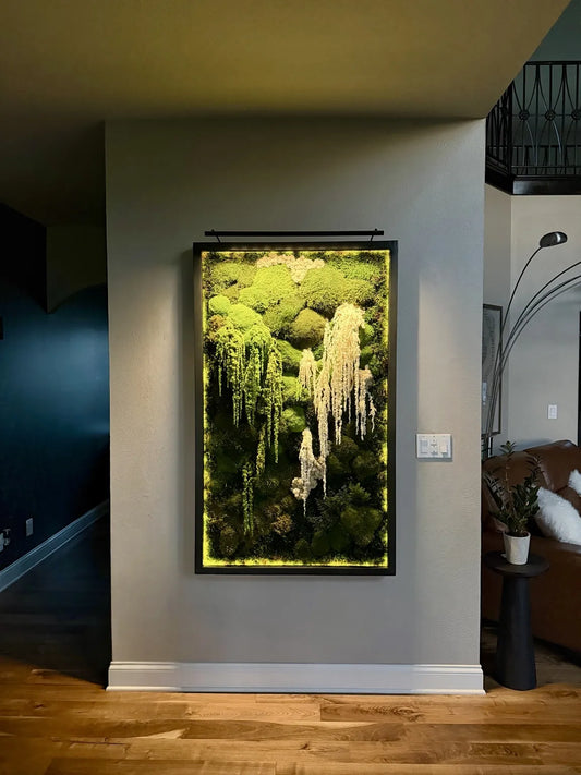 Framed vertical moss wall art with cascading greenery in a modern interior.