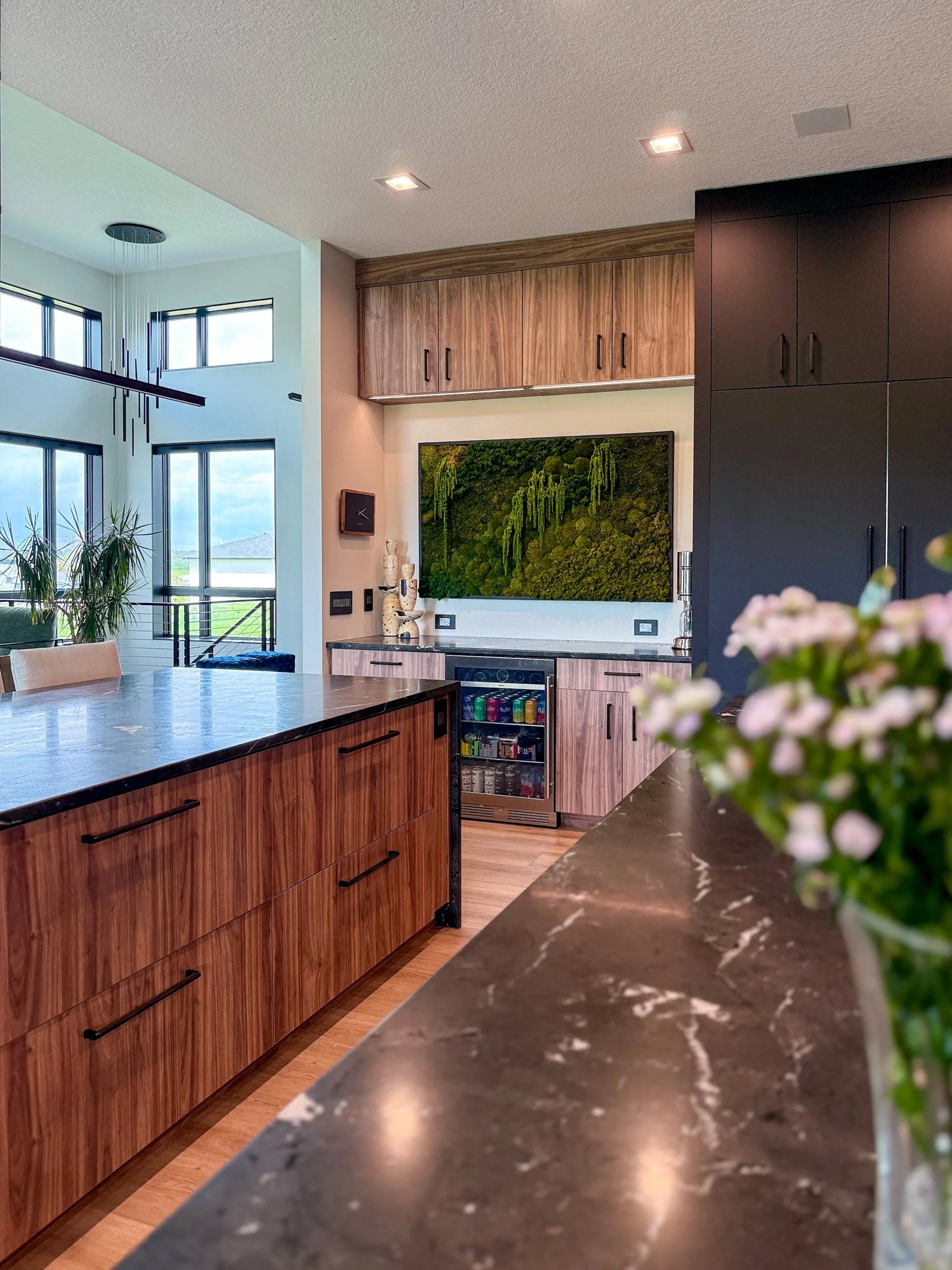 Modern black and walnut kitchen with luxury moss wall art and interior plants by Trendy Gardener