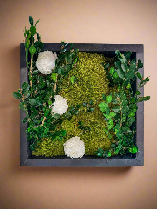 Preserved moss wall featuring lush green boxwood foliage and delicate preserved peonies, arranged in a naturalistic indoor vertical garden design.