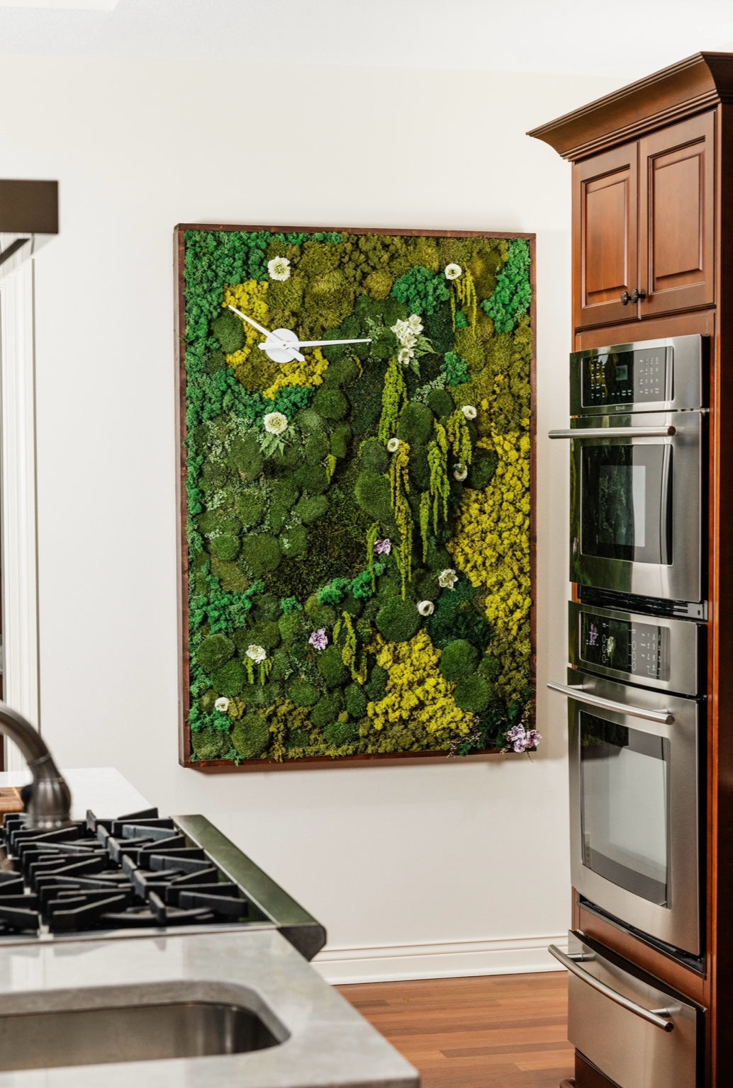 A statement moss wall installation, featuring mixed moss textures and floral elements, enhancing any corporate or residential space with natural tranquility.