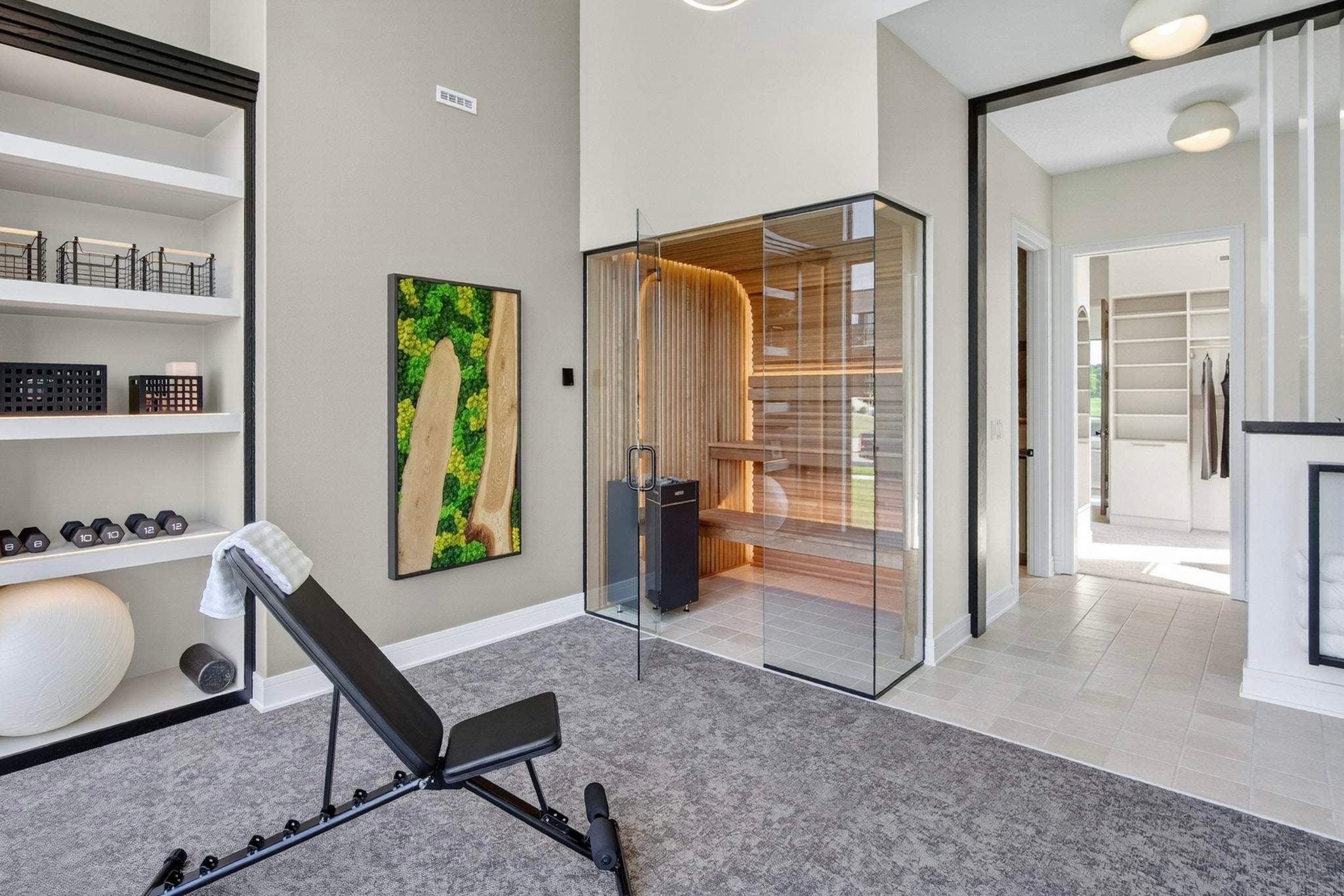 Custom live-edge wood and preserved moss wall art in home gym next to glass sauna, luxury wellness space biophilic design feature in Des Moines Home Builders Association Home Show, Trendy Gardener.