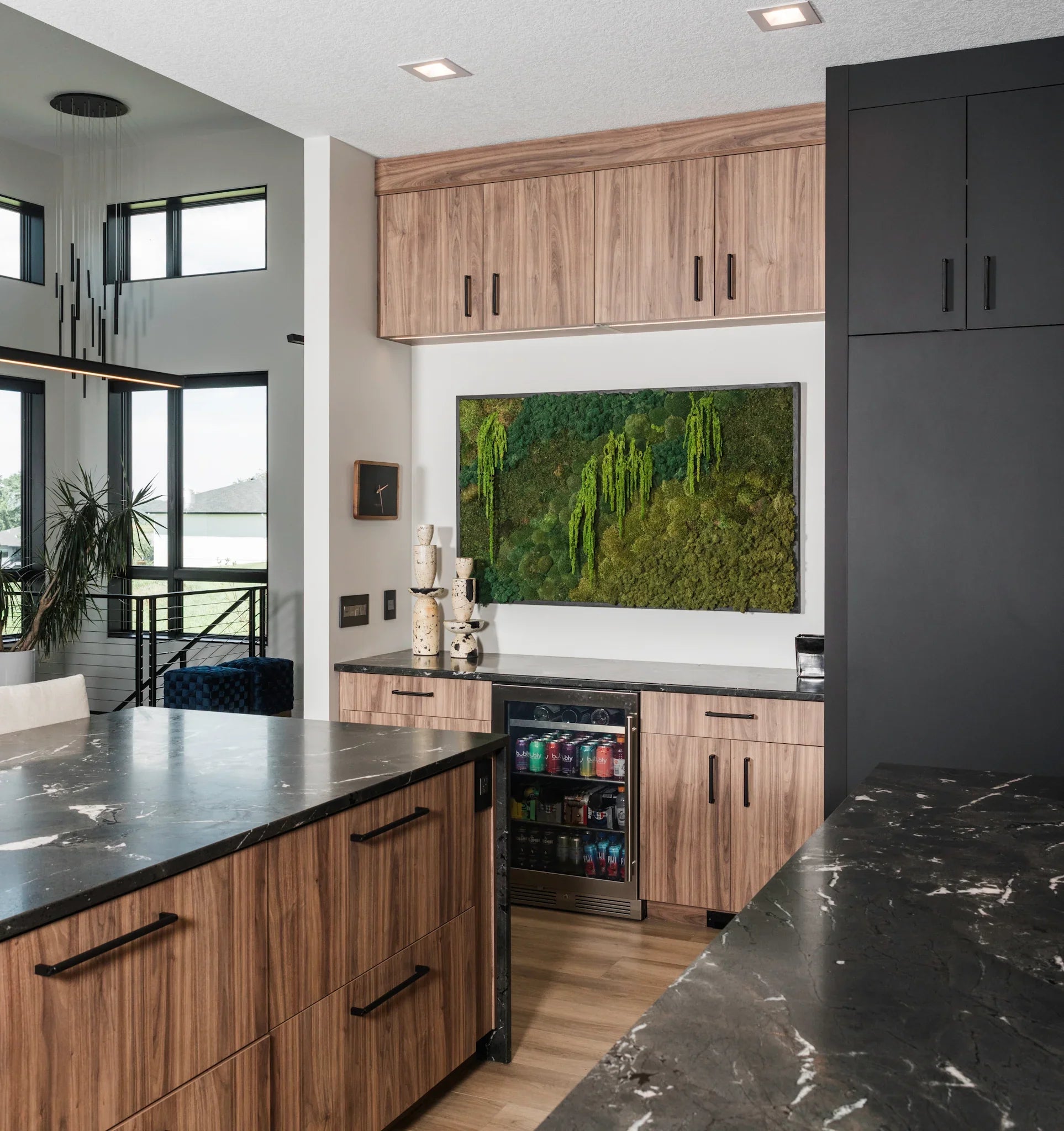 Modern kitchen with biophilic moss wall art, black countertops, wood cabinets, Trendy Gardener style