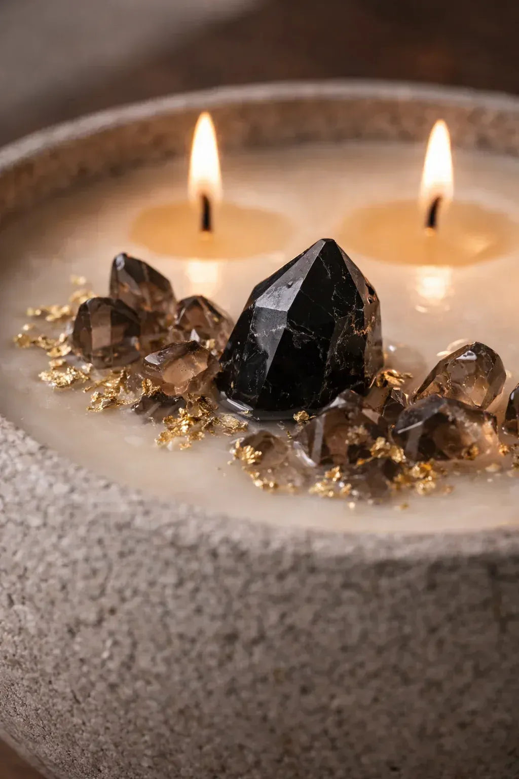 Luxury oud candle styled in an elevated interior with black obsidian and smoky quartz