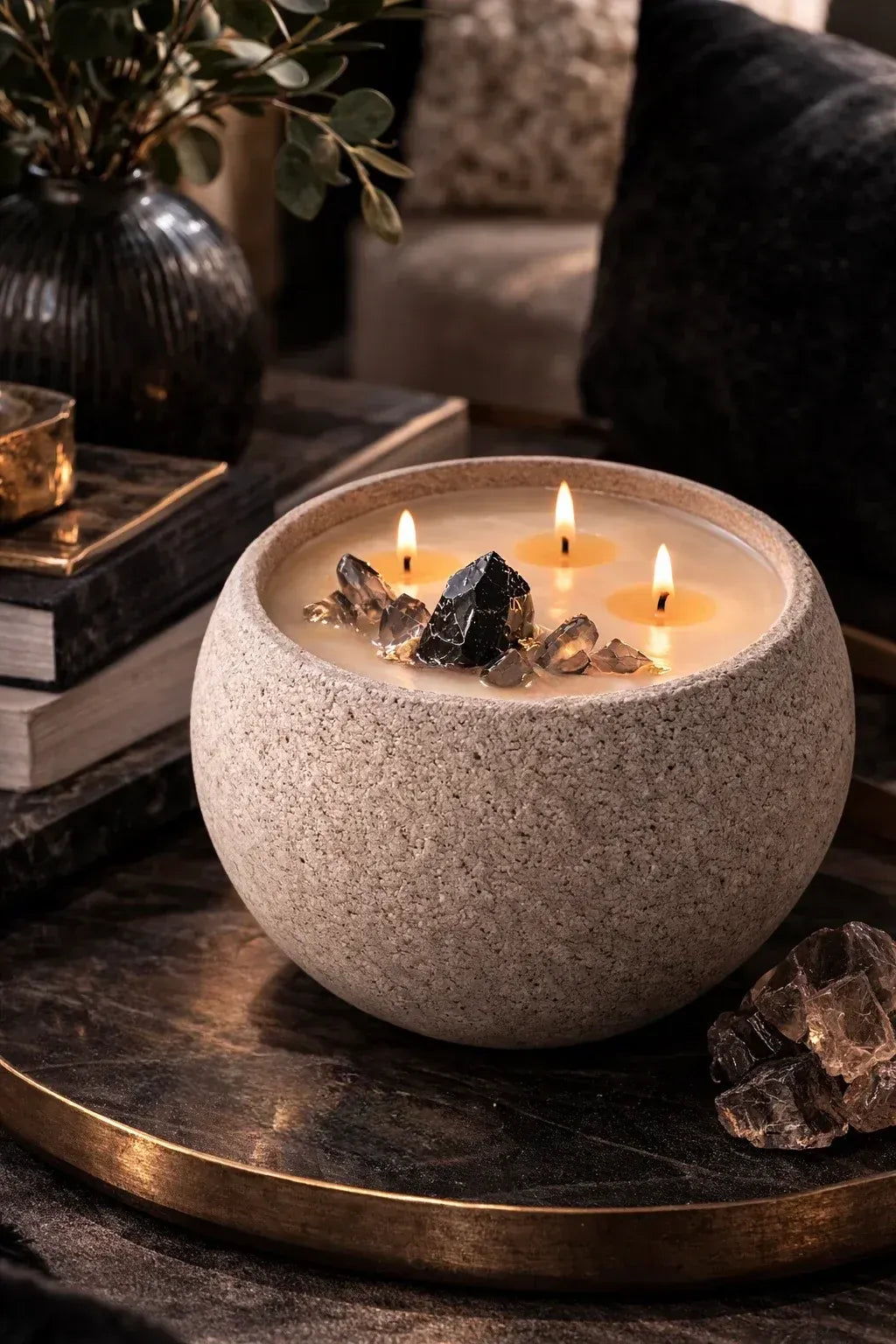 Noir + Oudh paraffin-free luxury candle in a concrete vessel with black obsidian and smoky quartz