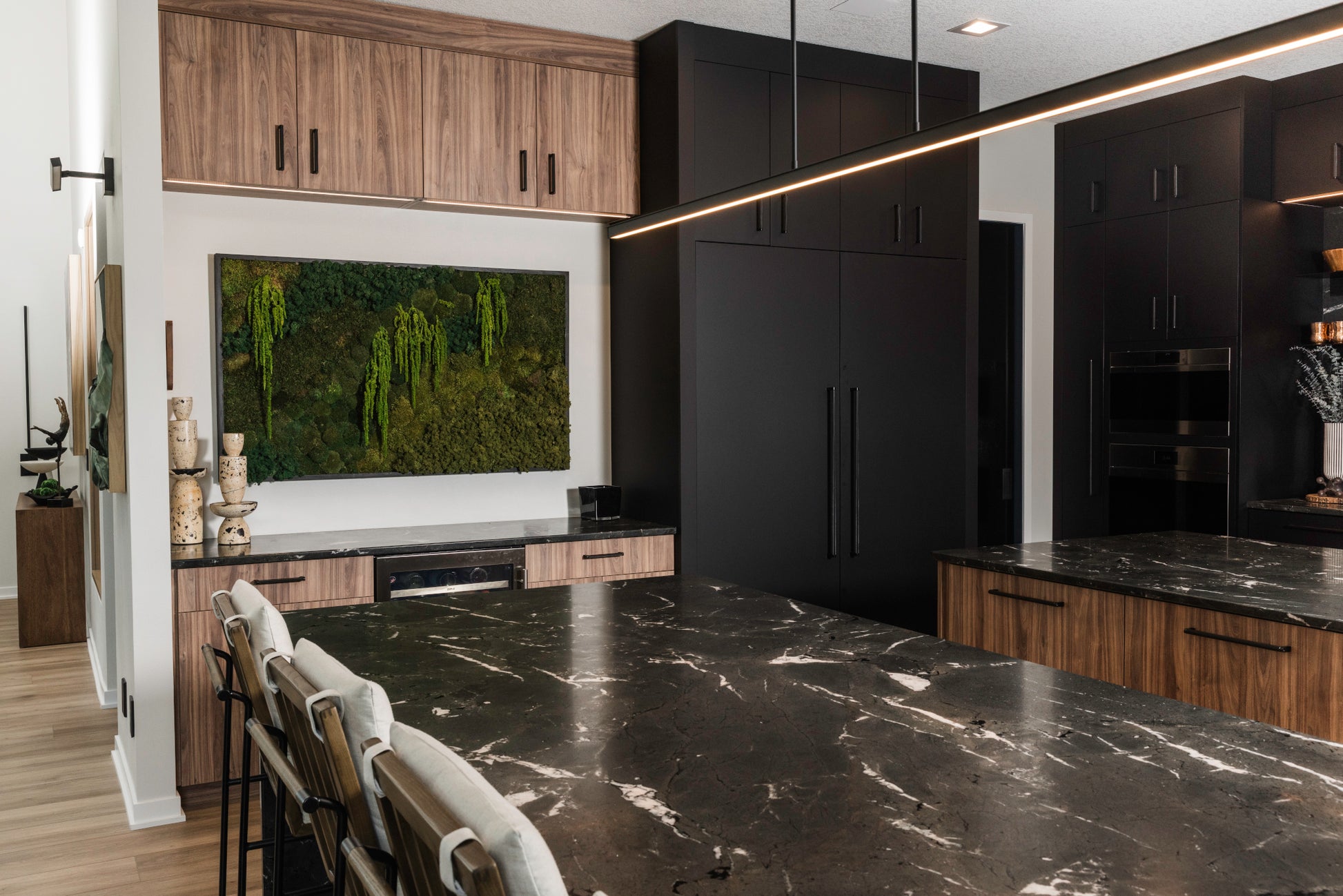 Modern kitchen with black marble countertops, wooden cabinets, and a custom preserved moss wall, residential moss wall, Des Moines, Iowa.