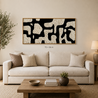 Large preserved ivory and black moss wall art in an oak frame above a cream sofa, shown in 72 by 36 inch size.