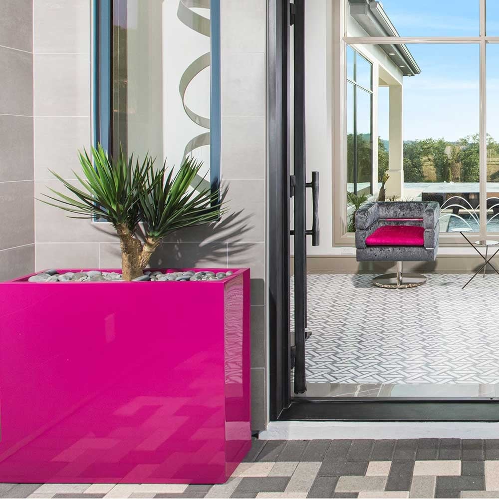 A vibrant bright pink Amesbury planter by Jamie Anand Interiors, featuring a sleek, modern design, ideal for adding a bold statement to indoor or outdoor plantscaping.