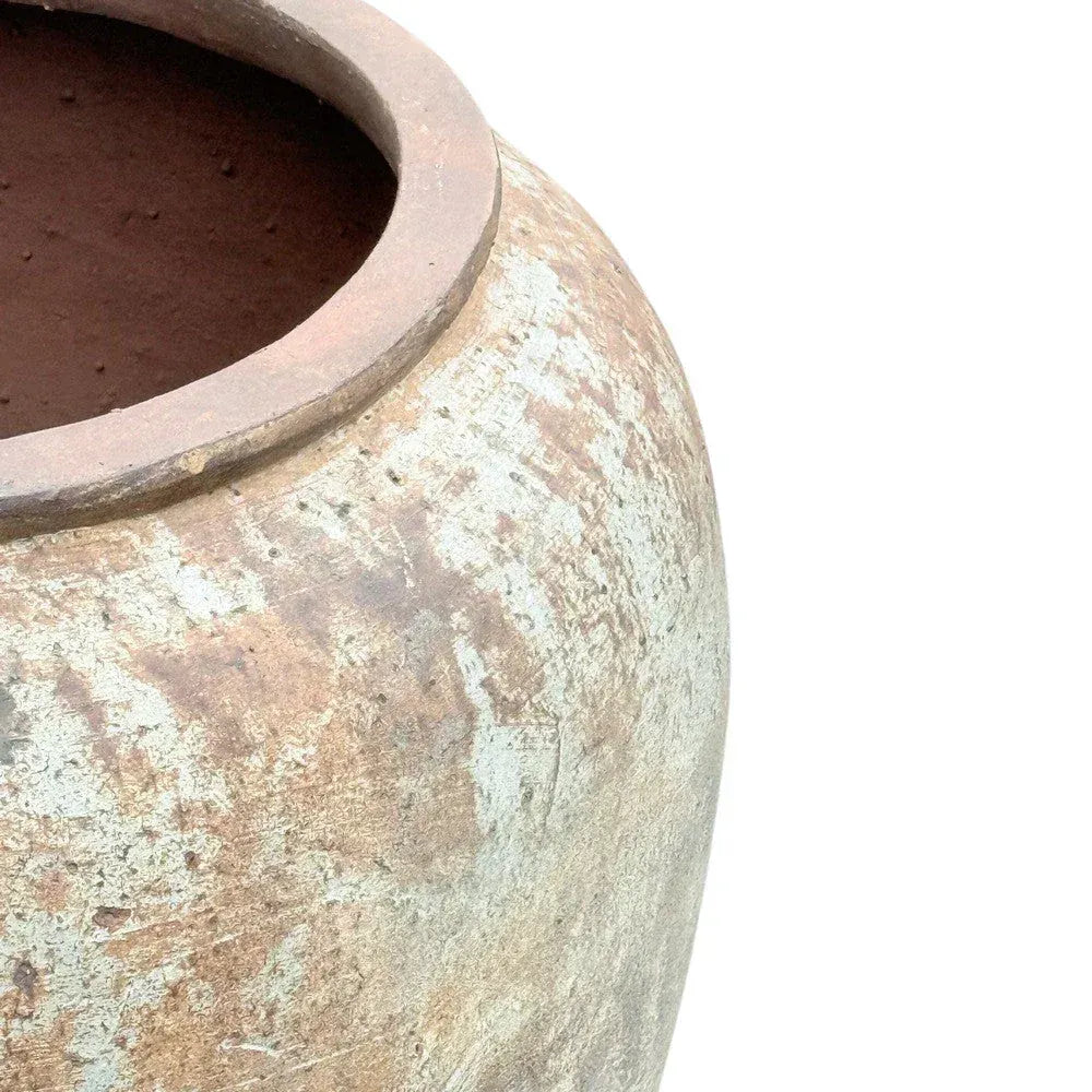 Large round terracotta planter styled outdoors on a patio or courtyard