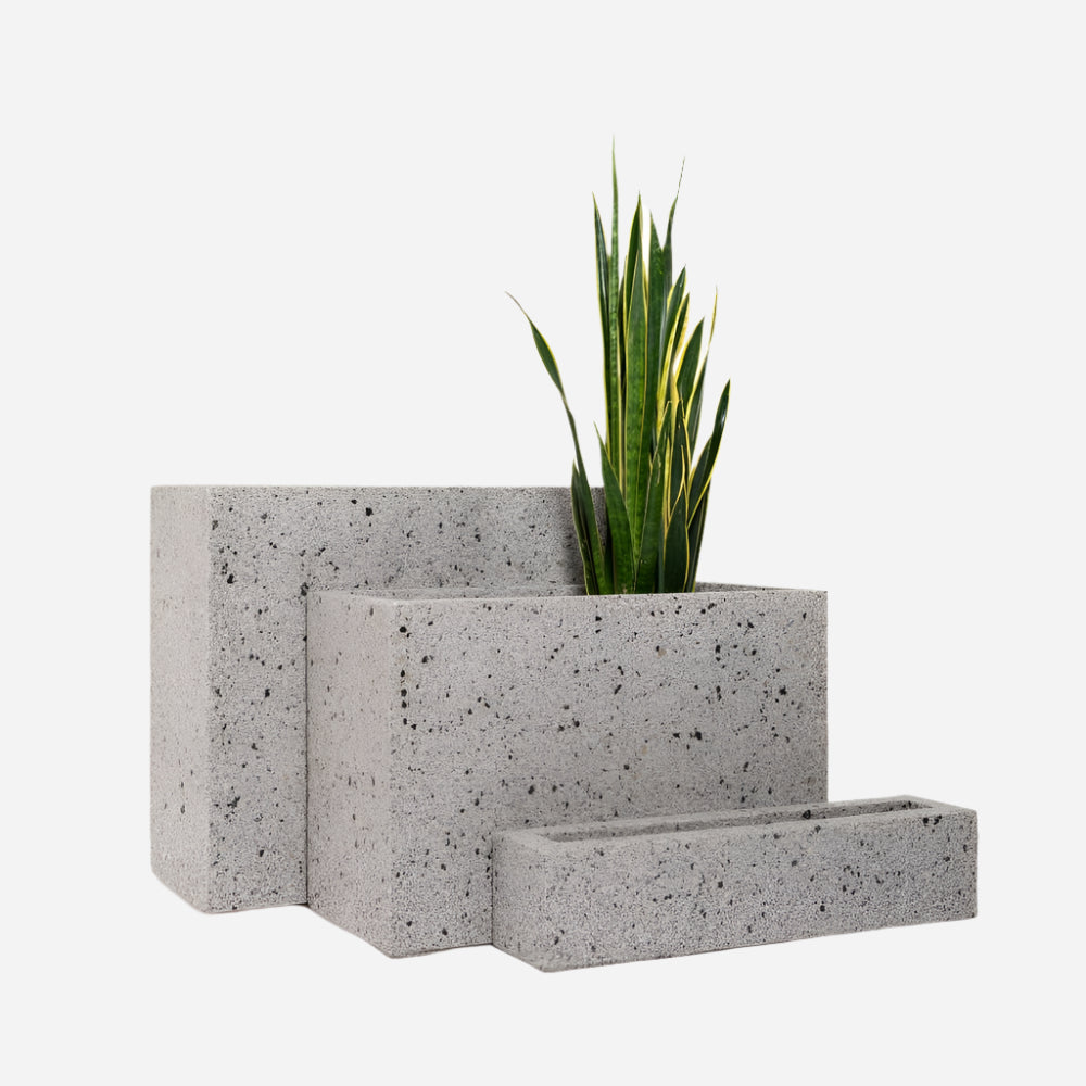 A tall rectangular white stone planter set of three in varying heights, showcasing a modern minimalist design, ideal for interior plantscaping and contemporary indoor or outdoor decor.